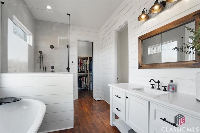 bathroom with wood-type flooring, separate shower and tub, and vanity