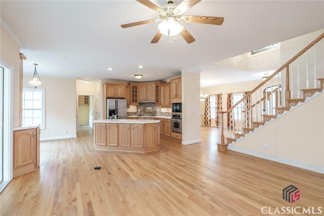 kitchen featuring backsplash, a kitchen island, light hardwood / wood-style floors, and appliances with stainless steel finishes