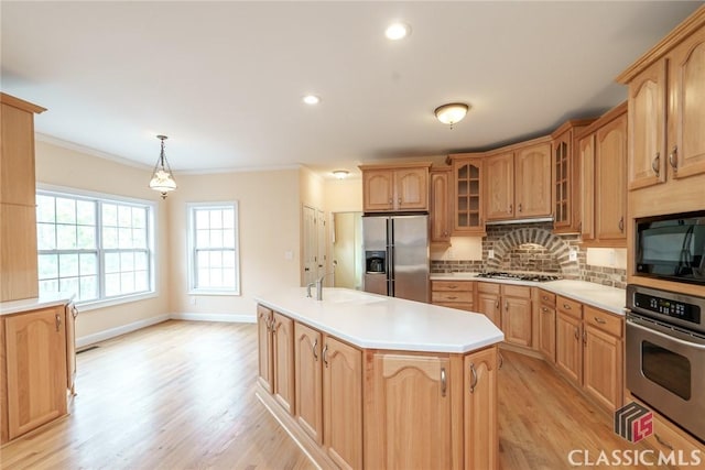 kitchen featuring sink, appliances with stainless steel finishes, tasteful backsplash, a kitchen island, and decorative light fixtures