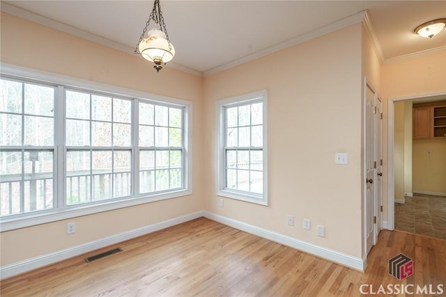 spare room featuring ornamental molding and light hardwood / wood-style flooring