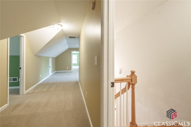 hall with light colored carpet and vaulted ceiling