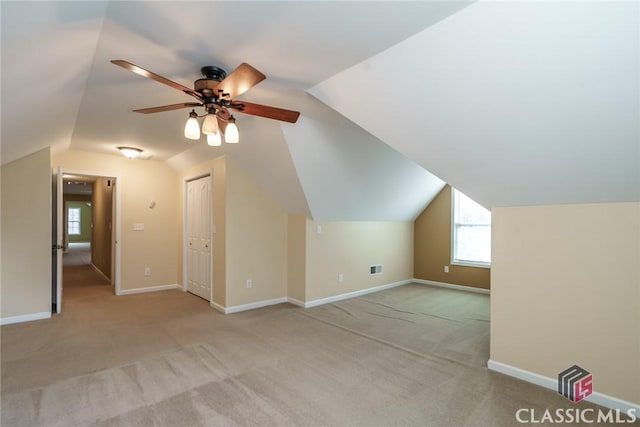 additional living space with lofted ceiling, light carpet, and ceiling fan