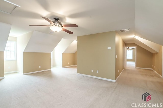 additional living space featuring lofted ceiling, light carpet, and ceiling fan