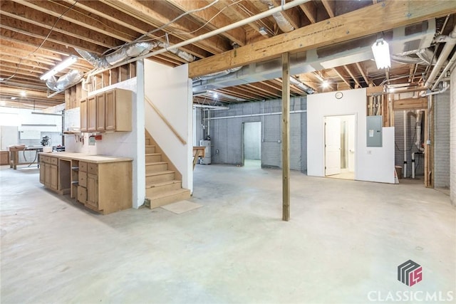 basement featuring strapped water heater and electric panel