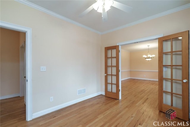 spare room featuring french doors, crown molding, ceiling fan with notable chandelier, and light hardwood / wood-style flooring