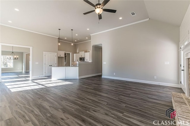 unfurnished living room featuring ceiling fan with notable chandelier, vaulted ceiling, ornamental molding, and dark hardwood / wood-style floors