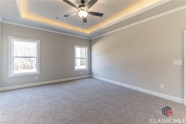 spare room with ceiling fan, a raised ceiling, and carpet floors