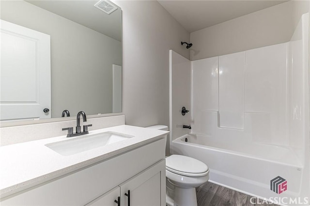 full bathroom with vanity, wood-type flooring, bathing tub / shower combination, and toilet