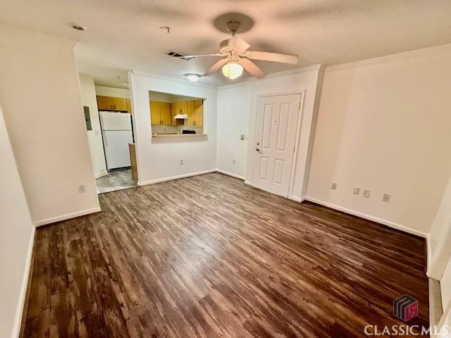 unfurnished living room with ceiling fan, crown molding, and dark hardwood / wood-style floors