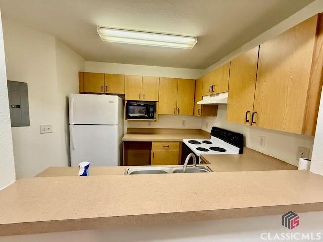 kitchen featuring black microwave, range with electric stovetop, electric panel, white fridge, and sink