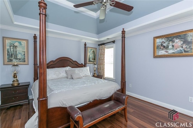 bedroom featuring dark hardwood / wood-style floors, ornamental molding, a raised ceiling, and ceiling fan