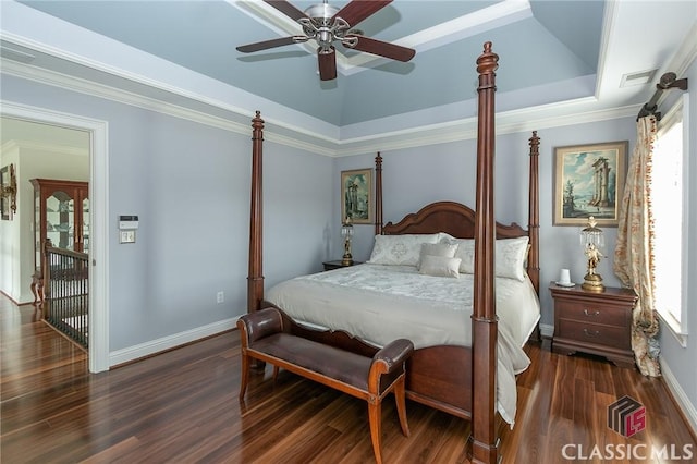 bedroom with ornamental molding, ceiling fan, dark hardwood / wood-style flooring, and a tray ceiling