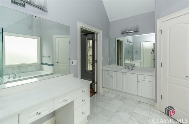 bathroom with lofted ceiling, vanity, and a washtub