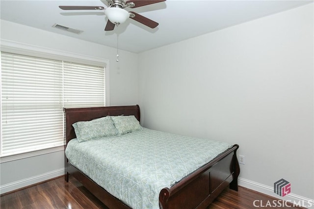 bedroom with multiple windows, dark wood-type flooring, and ceiling fan