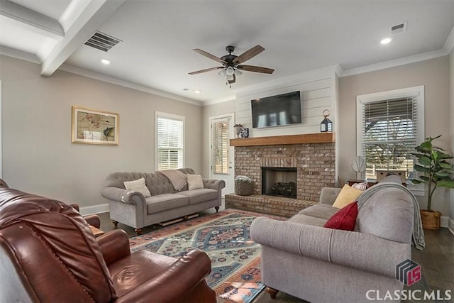 living room featuring dark hardwood / wood-style floors, a fireplace, beamed ceiling, ceiling fan, and crown molding