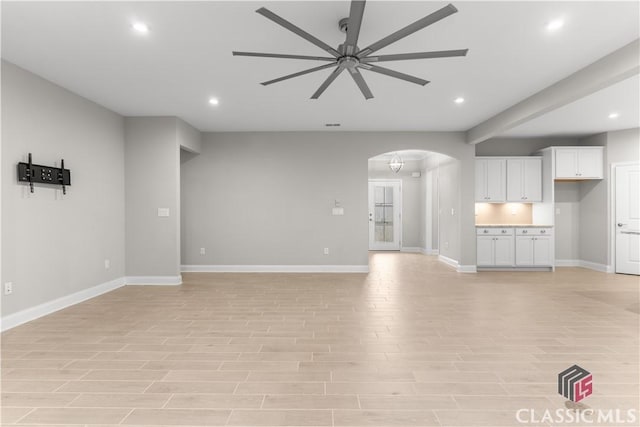 unfurnished living room featuring ceiling fan and light wood-type flooring