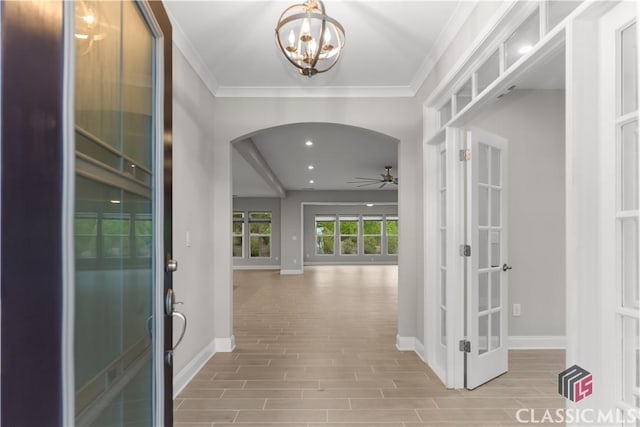 foyer featuring crown molding, ceiling fan with notable chandelier, and french doors