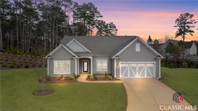 view of front of home with a garage and a lawn