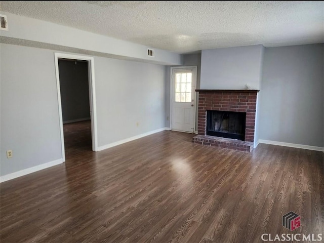 unfurnished living room with dark wood-type flooring, a fireplace, and a textured ceiling