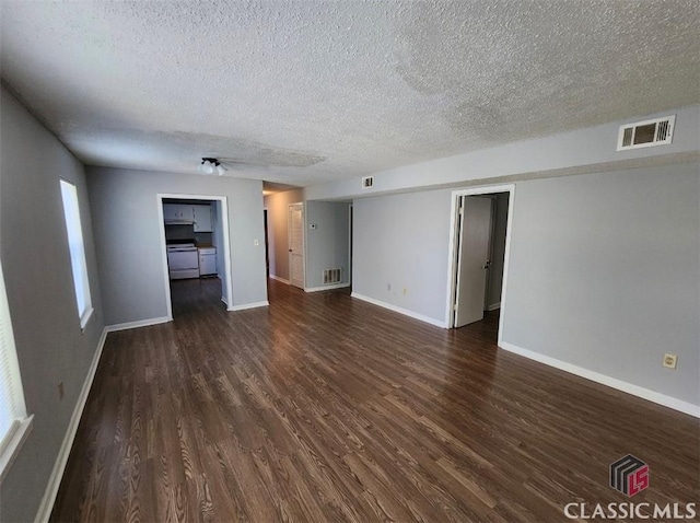 unfurnished room featuring dark wood-type flooring and a textured ceiling