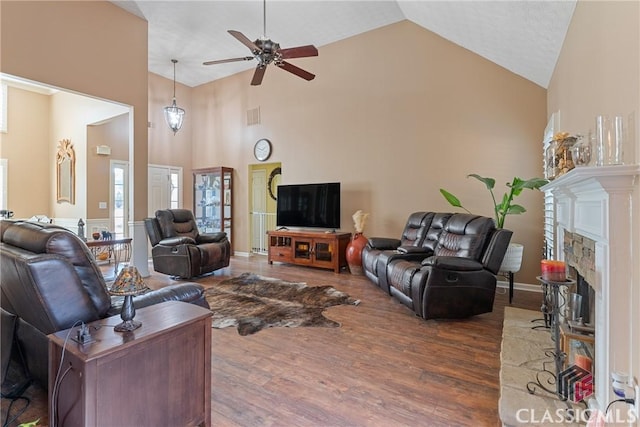 living room featuring ceiling fan, dark hardwood / wood-style floors, and high vaulted ceiling