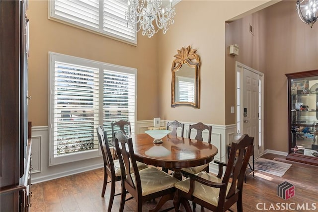 dining room featuring a high ceiling, dark hardwood / wood-style floors, and a notable chandelier