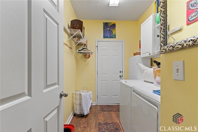 washroom with independent washer and dryer, cabinets, dark hardwood / wood-style floors, and a textured ceiling