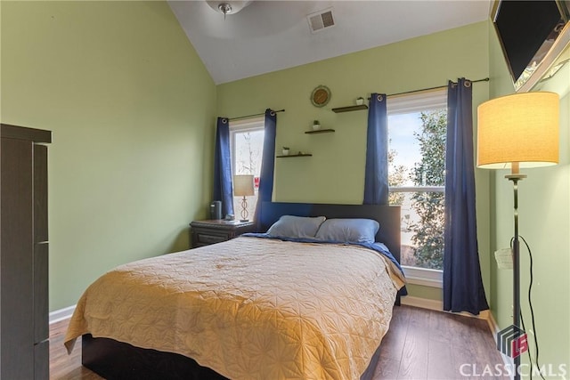 bedroom with dark hardwood / wood-style floors and vaulted ceiling