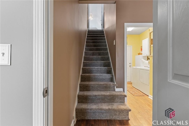 staircase featuring hardwood / wood-style flooring and washer and clothes dryer