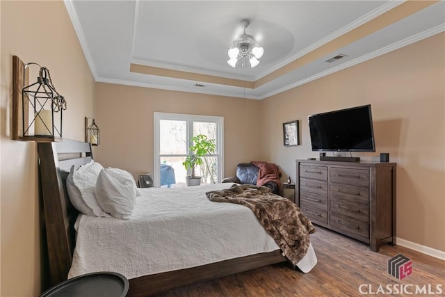 bedroom featuring ornamental molding, a tray ceiling, and hardwood / wood-style floors