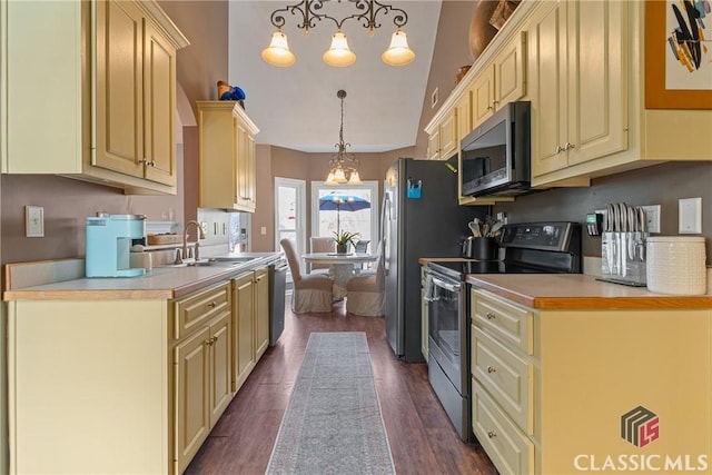 kitchen with sink, decorative light fixtures, dark hardwood / wood-style flooring, stainless steel appliances, and cream cabinets