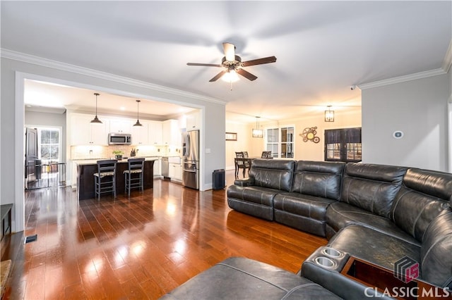 living room with crown molding, ceiling fan, and dark hardwood / wood-style flooring