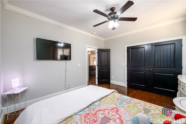 bedroom with ornamental molding, dark hardwood / wood-style floors, ceiling fan, and a closet