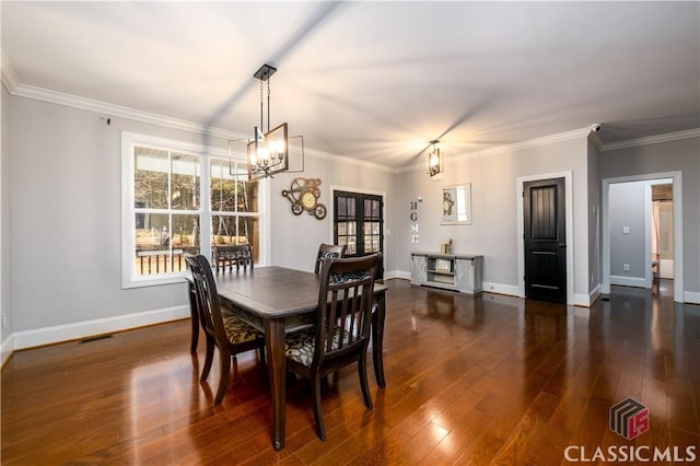 dining room featuring ornamental molding, dark hardwood / wood-style floors, and a chandelier