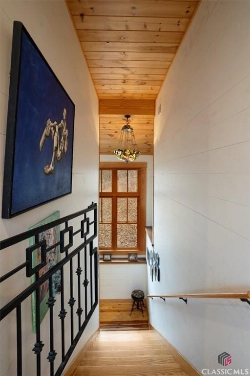staircase with wood finished floors and wood ceiling