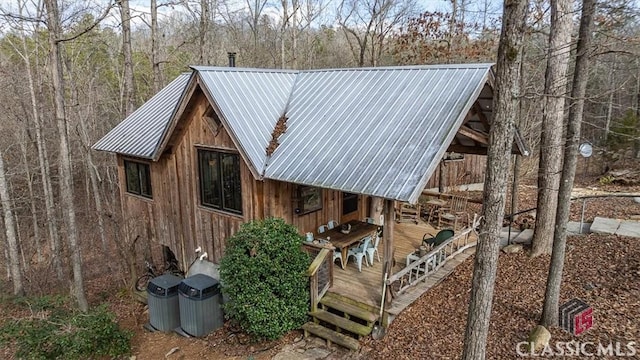 view of home's exterior with metal roof and a wooden deck