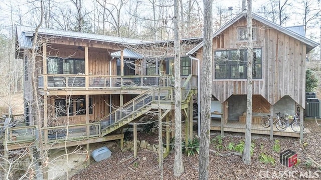 exterior space featuring central AC, stairway, metal roof, and a wooden deck