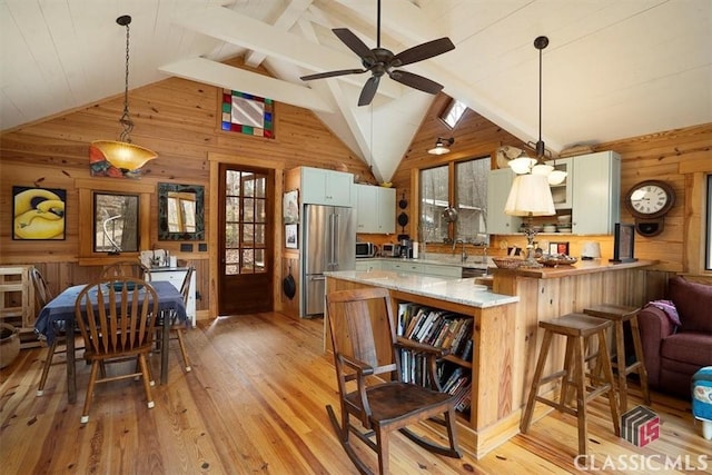kitchen featuring light wood finished floors, wooden walls, open shelves, and stainless steel appliances