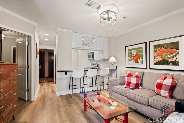 living room featuring crown molding and light hardwood / wood-style floors