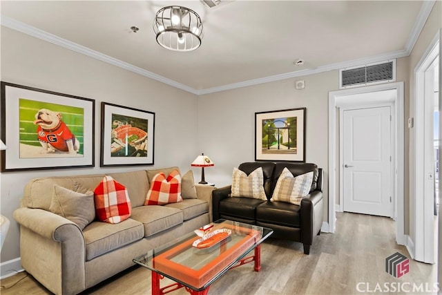 living room with ornamental molding, a chandelier, and light wood-type flooring