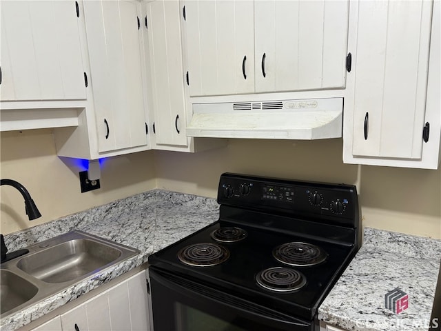 kitchen featuring light stone counters, black / electric stove, sink, and white cabinets