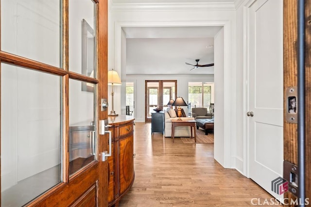 hallway featuring ornamental molding and light wood-type flooring