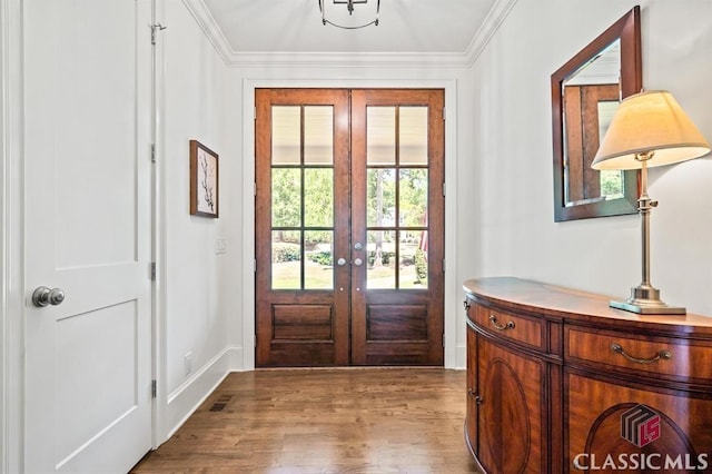 doorway featuring ornamental molding, french doors, and light wood-type flooring