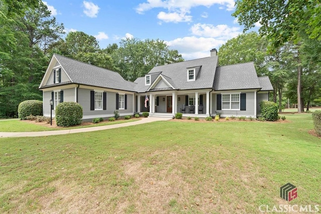 new england style home featuring covered porch and a front lawn