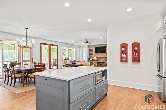 kitchen featuring gray cabinetry, hanging light fixtures, plenty of natural light, stainless steel appliances, and a kitchen island