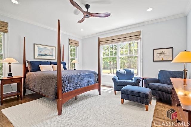 bedroom featuring hardwood / wood-style floors, ornamental molding, and ceiling fan