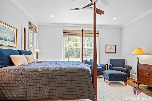 bedroom featuring ceiling fan, ornamental molding, hardwood / wood-style floors, and multiple windows