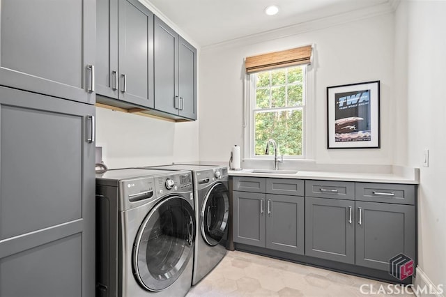 laundry room featuring crown molding, cabinets, separate washer and dryer, and sink