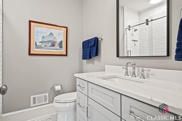 bathroom featuring vanity, toilet, and a tile shower