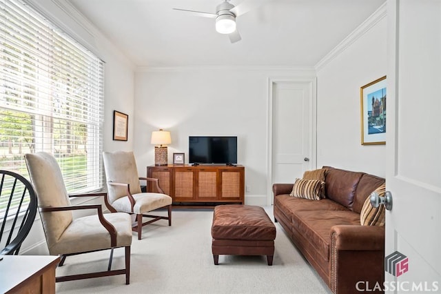 carpeted living room featuring ceiling fan and ornamental molding